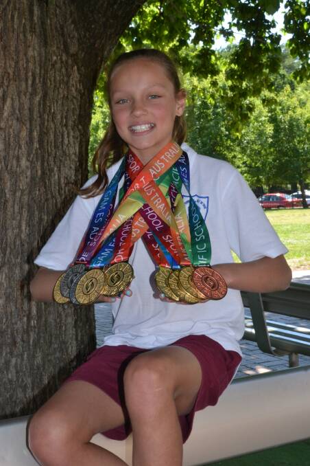 WINNERS ARE GRINNERS: Collette Lyons with her collection of nine medals – six of which are gold – from the recent Pacific School Games. Photo: ALEXANDER GRANT 	113015aglyons1
