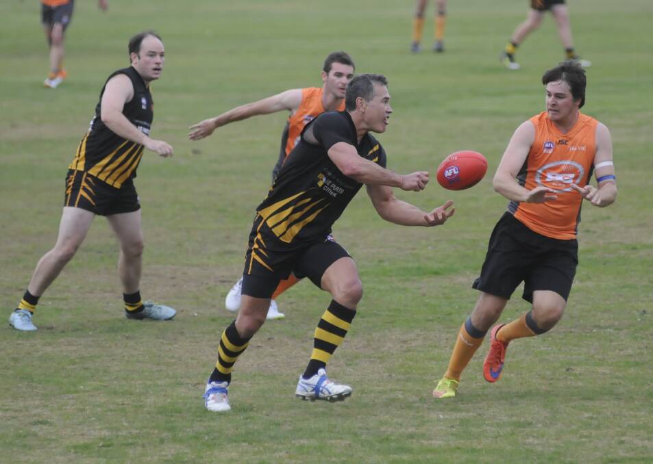 DOUR: Orange Tiger Eddie Te Paa handballs past Greg Reid for the Bathurst Giants during their 34-point win over the Bathurst team on Saturday. Photo: CHRIS SEABROOK	 050716caflg1