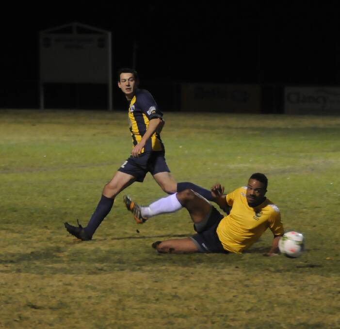 GOOD RESULT: Charlie McDonald Bailey (right) wins the ball in a slide tackle during Saturday night’s 1-all draw with State League 1 leaders Hills Brumbies. Photo: CHRIS SEABROOK 	052315cmsoc4a