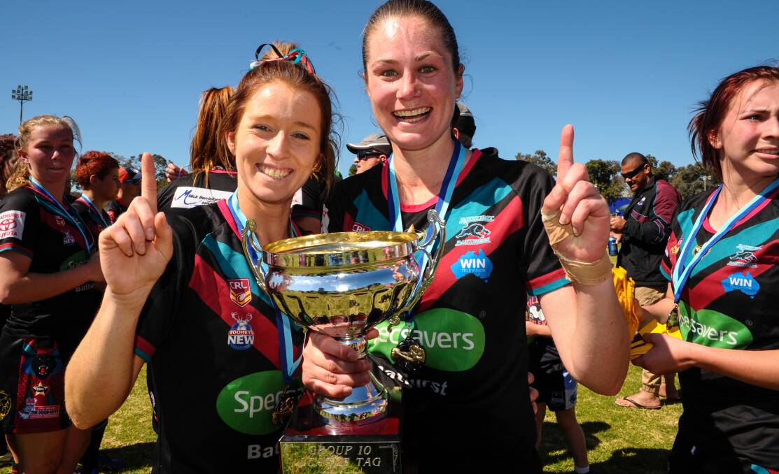 PERFECT SEASON: Bathurst Panthers playmaker Jess Hotham (left) was player of the match in Sunday’s grand final win over St Pat’s, and was only too happy to get her hands on the premiership trophy along with captain Monique Christie-Johnson. Photo: ZENIO LAPKA 	091414zgirlswin1