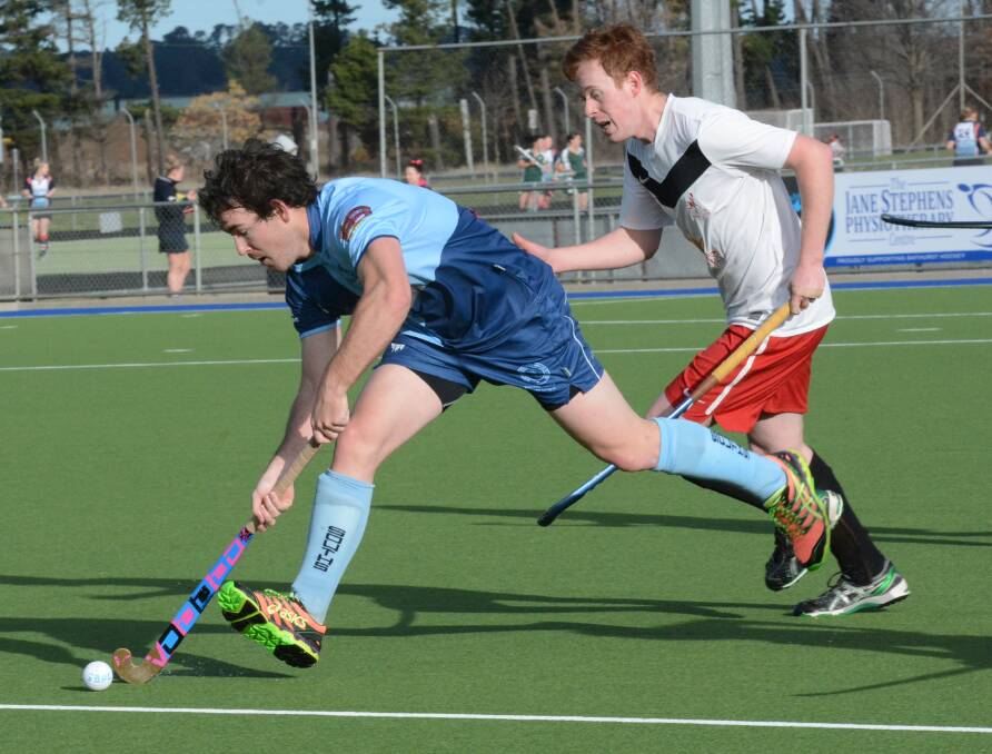 TOUGH DAY: Souths striker Jono Cole is chased by Parkes' Michael Minnett in their men's Premier League Hockey match on Saturday. While South went into the match sitting six places ahead of their rivals on the ladder, it was Parkes who won 4-1. Photo: PHILL MURRAY 080115pparkes1