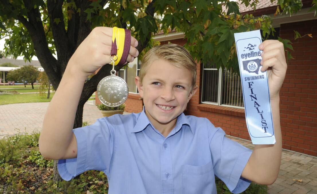 LITTLE FISH: Year 4 Assumption School student Toby Partridge with his Polding silver medal and ribbon from swimming at the state titles. Photo: CHRIS SEABROOK 	033015ctoby