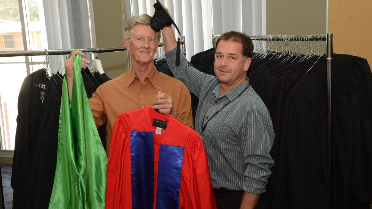 HATS OFF: Charles Sturt University public affairs officer Bruce Andrews and food and beverages manager Brett Russell preparing gowns before this week’s graduation ceremonies. Photo: PHILL MURRAY	 121614pcsu