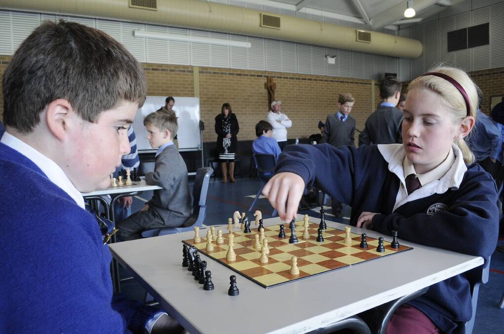 CHECK MATES: The Scots School’s Austin Markwick plans his next move as Shona Jarvis from St Philomena’s takes her turn during the inter-school chess tournament at St Philomena’s yesterday. Photo: CHRIS SEABROOK	 072214chess1a