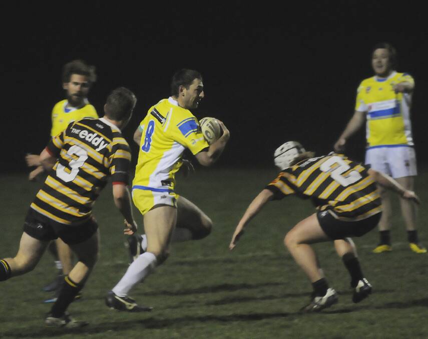 RIVALRY: Mungoes’ Rob McMahon takes on the Mustards’ defence in Wednesday night’s charity rugby league match. The Mustards rugby union side got the better of the Mungoes at their own game 22-20. Photo: CHRIS SEABROOK	  091714csufooty1
