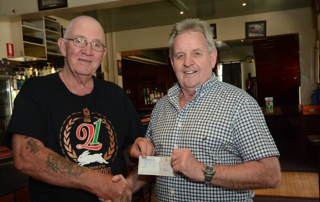 IT WILL GO A LONG WAY: Barney Rumble receives a cheque for $1500 for his annual community Christmas lunch from Robert ‘Stumpy’ Taylor on behalf of the Bathurst Liquor Accord. Photo: PHILL MURRAY 121614obarney
