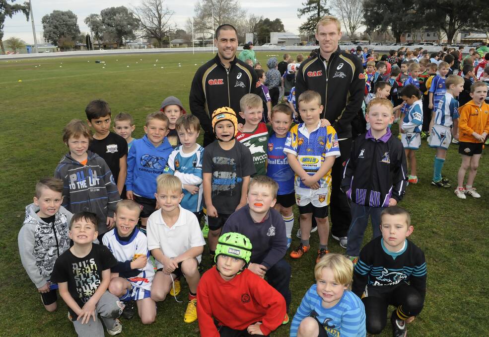 HALF AS GOOD AGAIN: Penrith Panthers halves Jamie Soward (left) and Peter Wallace with some of the hundreds of kids who turned up for the junior rugby league training clinic at the Sportsground yesterday. Photo: CHRIS SEABROOK 	072314cpenpan1
