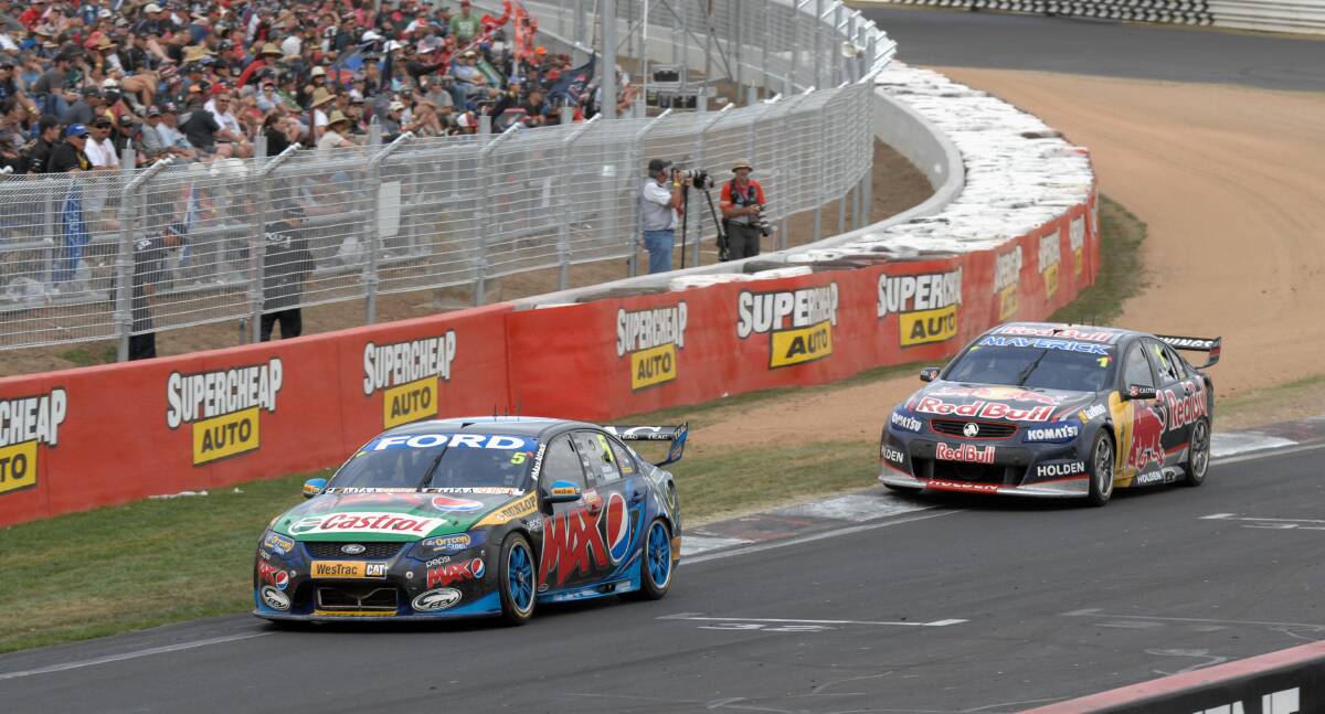 COLLISION COURSE: Mark Winterbottom leads Jamie Whincup in the dash to the chequered flag in last year’s Bathurst 1000. While the weekend of the Great Race is a big one in Australian sport, it could clash with the AFL grand final in 2015. Photo: ZENIO LAPKA 	101313zfinish