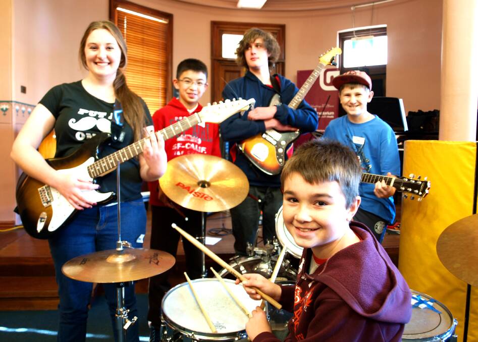 BANDING TOGETHER: Ryley Davison (front), Emma Seager, Anthony Tran, Nick Martin and Jak Woodward are learning new skills with new people as part of the Rock School program at the Mitchell Conservatorium. Photo: ZENIO LAPKA	 070214zrock