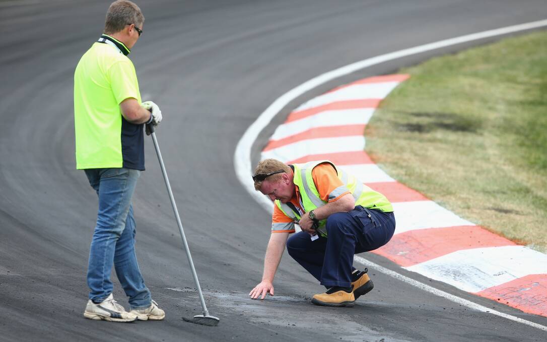 CONCERN: Track officials look at the problem area during yesterday’s Bathurst 1000. Photo: Robert Cianflone/Getty Images