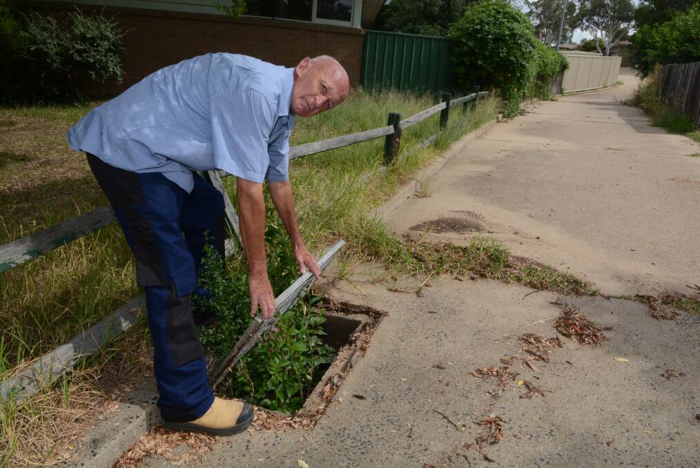 TIME FOR A CLEAN-UP: Jeff Milne shows the blocked drain in the laneway off Havenhand Way. He says the walkway has been left in a poor state for too long. Photo: PHILL MURRAY	 022615pjeff