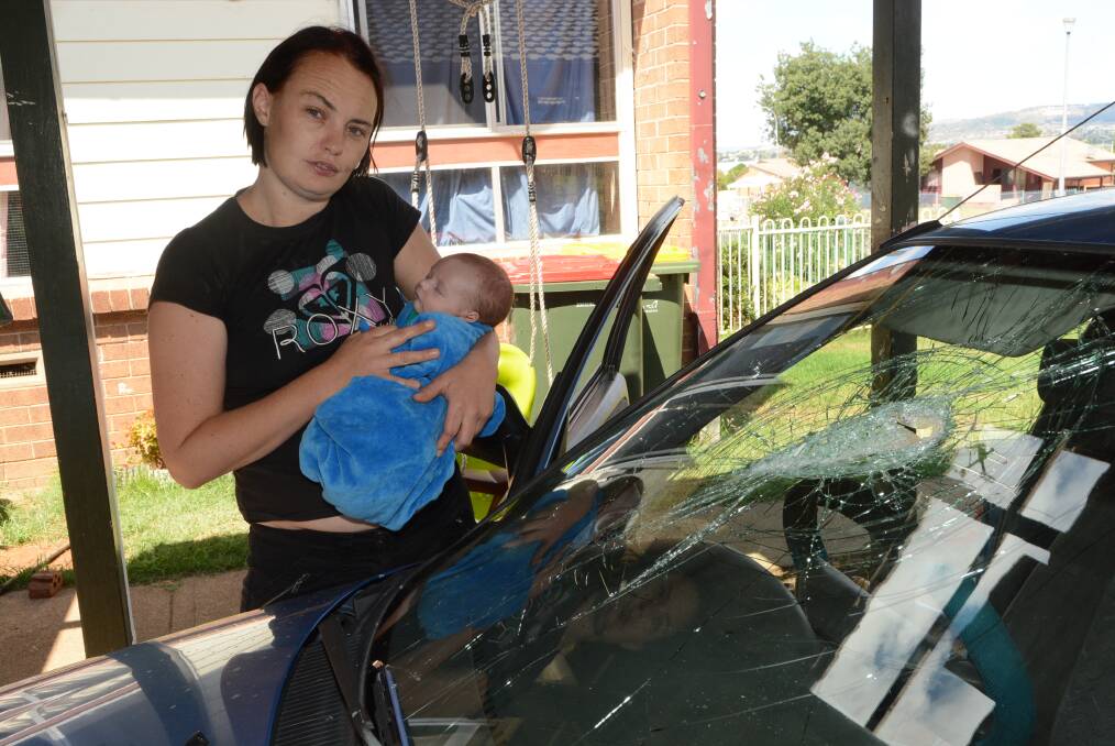 NOT SAFE: Jody Croft, pictured with her new baby John, says her car was trashed by a group of 30 people throwing bricks. One of the bricks, which went through the front window of the house, narrowly missed John’s head as he slept. Photo: PHILL MURRAY	 022515pkelso