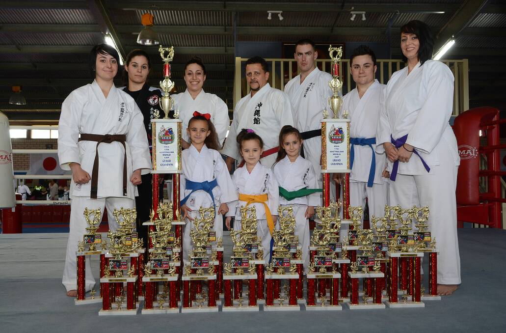BIG HAUL: Pollet’s Martial Arts competitors (back row) Giamia Radice, Amanda Doueihi, Jess Doueihi, Hanshi Ian Pollet, Chris Mckay, Dalton Walker and Nikki Plaisted and (front) Ava Pollet, Tyra Pollet and Lexie Pollet after their recent success at Sydney. Photo: PHILL MURRAY 	102114ppollet