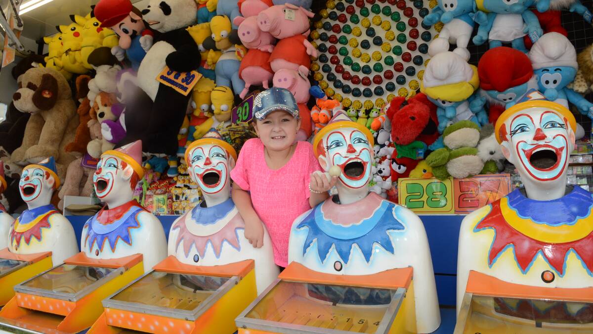 CLOWNING AROUND: Sascha Parker-Eade, 8, had a closer look at the laughing clowns as preparations for the Royal Bathurst Show wound up yesterday. The clowns will again be among the most popular sideshow alley attractions when the show kicks off today. Photo: PHILL MURRAY	 0411615pshow4
