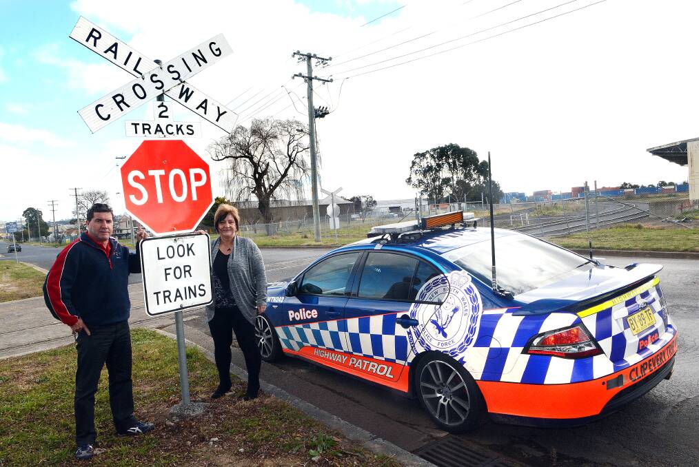 STOP AND LOOK: Councillor Warren Aubin and Tablelands Area road safety officer Iris Dorsett warn motorists that trains will once again be using the rail line which crosses Toronto Street in Kelso from this week. Photo: PHILL MURRAY 071114prail