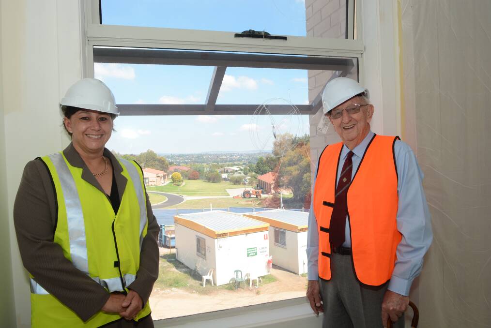 NEARING COMPLETION: The Whiddon Group director of care services at Kelso Nicole Mahara and soon-to-be first resident Alex Bedwell take a look through the new 60-bed facility. Photo: PHILL MURRAY	 022715pwhiitton