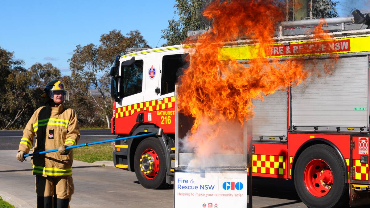 ALL TOO EASY: Fire and Rescue NSW senior firefighter David Press demonstrates how easily a kitchen fire can get out of control. Photo: ZENIO LAPKA 	060814zkitchen