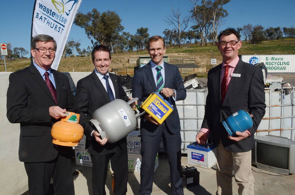 WASTE NOT: Bathurst mayor Gary Rush, Bathurst MP Paul Toole, Environment Minister Rob Stokes and Blayney Council deputy mayor Allan Ewin with gas bottles and car batteries which residents will soon be able to take to the Bathurst waste management centre following the announcement of a state grant yesterday. Photo: PHILL MURRAY	 070314prubbish