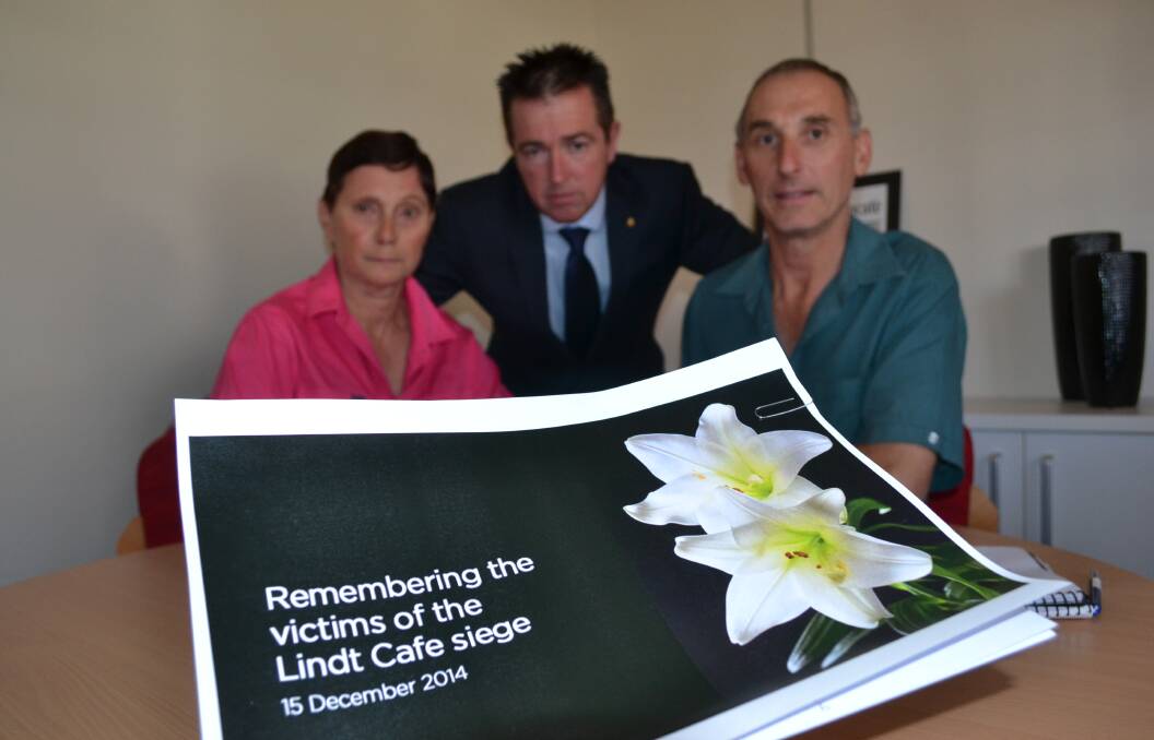 MOVED TO ACT: Bathurst residents Lesley and Keith Worthington called into Bathurst MP Paul Toole’s office yesterday to sign a condolence book dedicated to those who lost their lives during the Lindt Cafe terrorism siege in the Sydney CBD earlier this week. Photo: BRIAN WOOD	 121714condolence