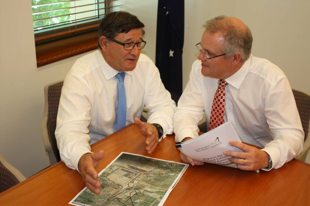 ON TRACK: Member for Calare John Cobb and federal treasurer Scott Morrison look over plans for the proposed second track to be built at Mount Panorama.	 021016track