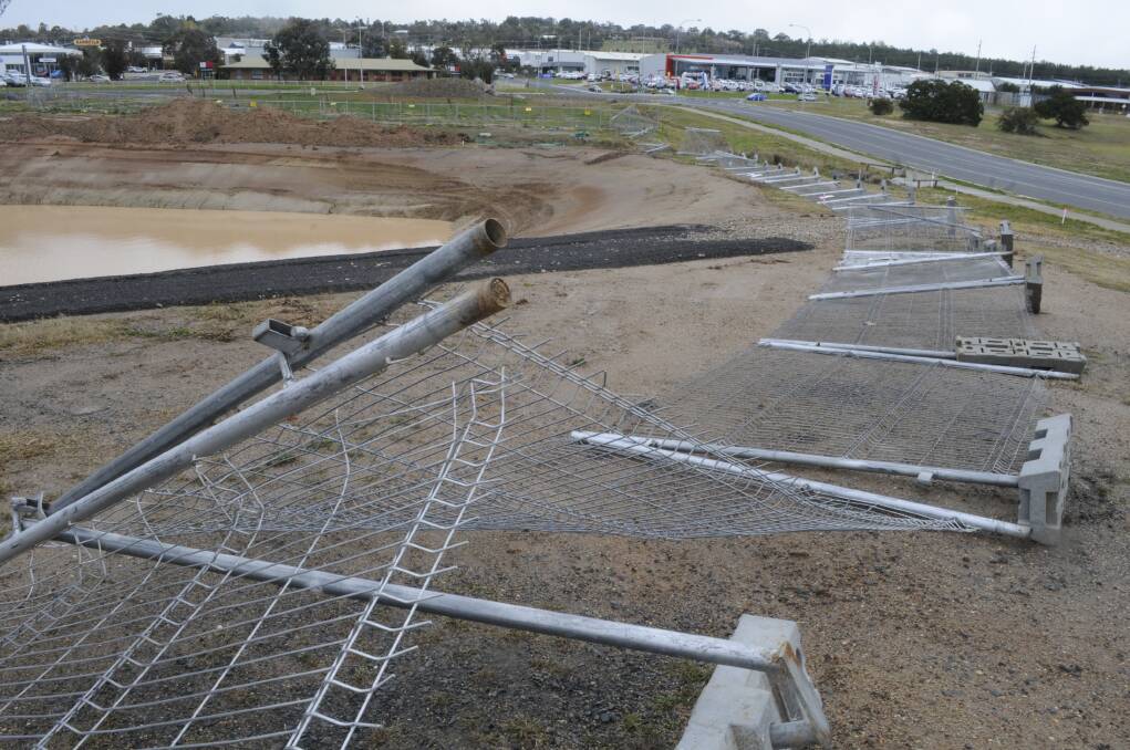 DOMINOS: A long section of fencing around the reflection pond under construction at Bathurst Cemetery fell over in gusty weather. Photo: CHRIS SEABROOK 	071315cdominos