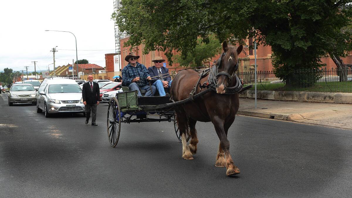THE LAST RIDE: Neville Goldspink and Samson lead Mervyn Theobald’s funeral procession down Keppel Street with one of Mervyn’s sons Paul riding shotgun. Photo: PHILL MURRAY 	012815pmerve