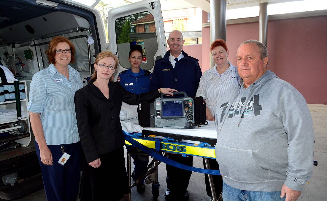 SAVING LIVES: Estelle Ryan CNC Cardiology, Cardiologist Dr Ruth Arnold, paramedics Claire Green and Adam Parker, Anne Morrison NUM ICU and Coronary Care and bypass patient Terry Babbage with the lifesaving ECG machine. Photo: PHILL MURRAY 100714pheart