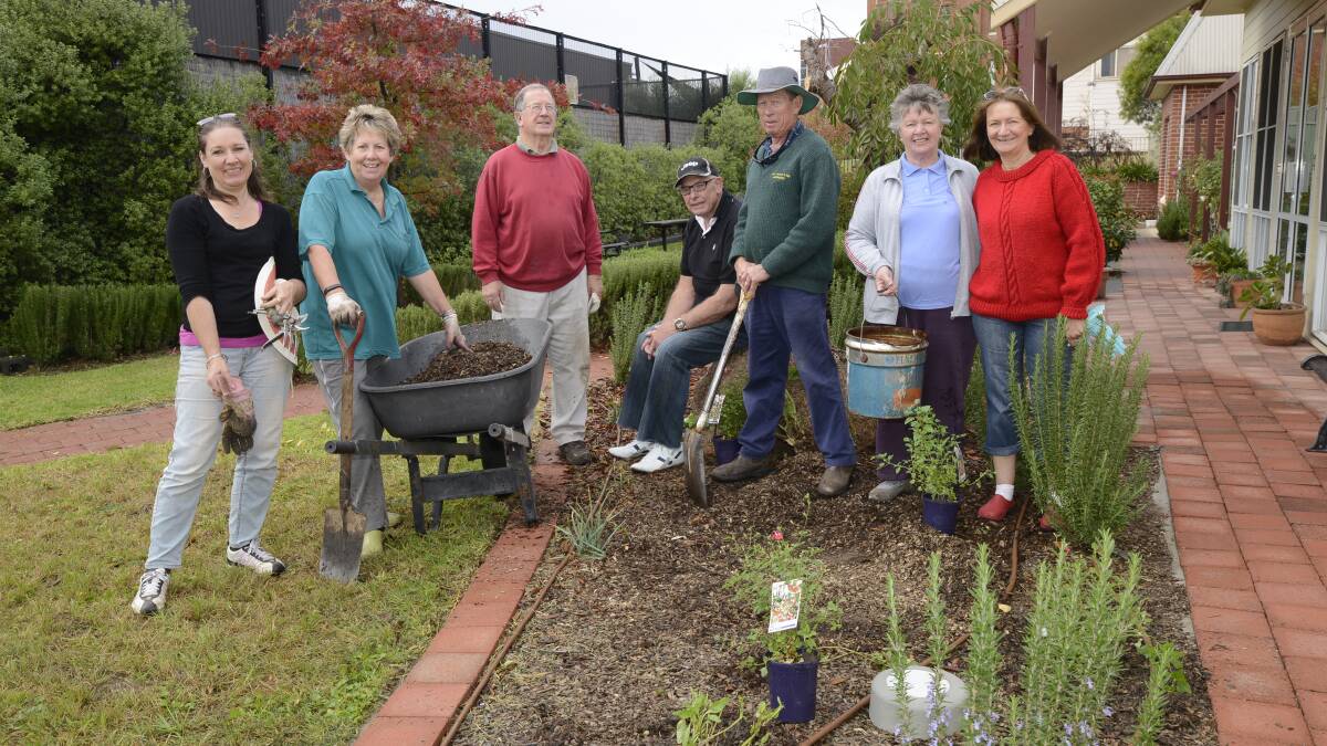 COMMUNITY PROJECT: Bathurst Garden Club president Karen Granger (left) and members Anne Llewellyn, Ted Reedy, Don Stafford, Peter Varman, Gwen Stafford and Elizabeth Gilchrist were at Daffodil Cottage on Saturday to replant the garden. Photo: PHILL MURRAY 043016pgradens