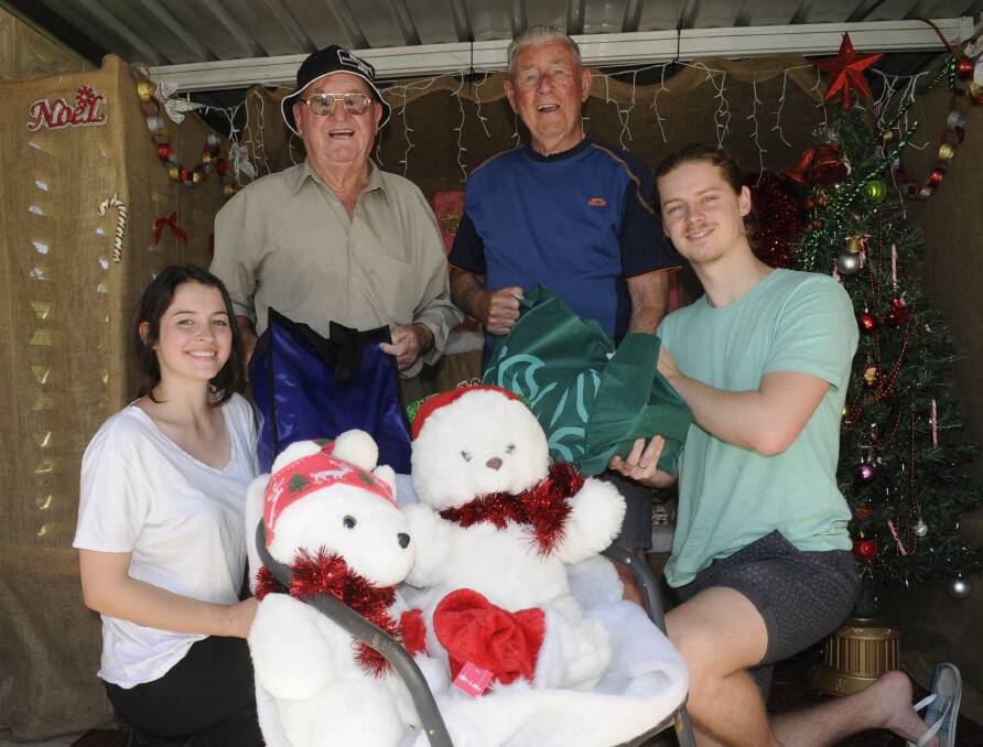 MERRY CHRISTMAS TO YOU: Tony McGrath, second from left, and Clive Coles receive their Christmas hampers from Avril Bryant, left, and Alex Morgan, right, at Chifley Retirement Village yesterday. Photo: CHRIS SEABROOK 	122114champer2