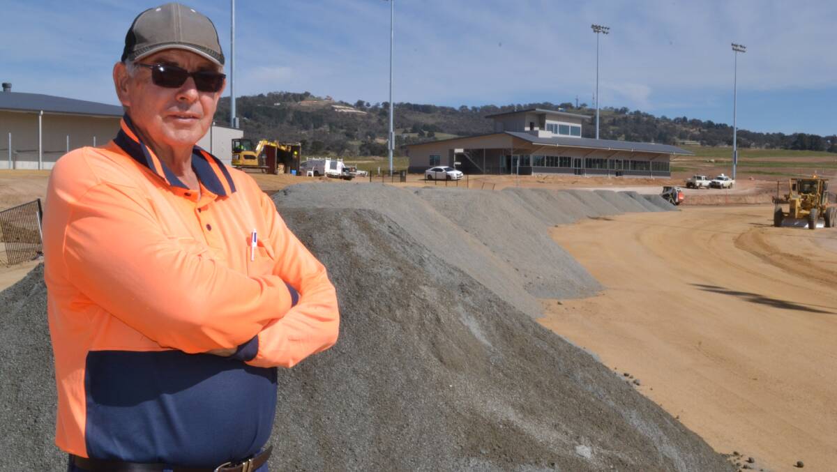 DUST UP: Paul Sherley from Divall’s Earthmoving and Bulk Haulage in Goulburn at the new Bathurst Harness Racing complex yesterday preparing to put down 6000 tonnes of crusher dust on the racing surface. Photo: BRIAN WOOD 090114cinders1