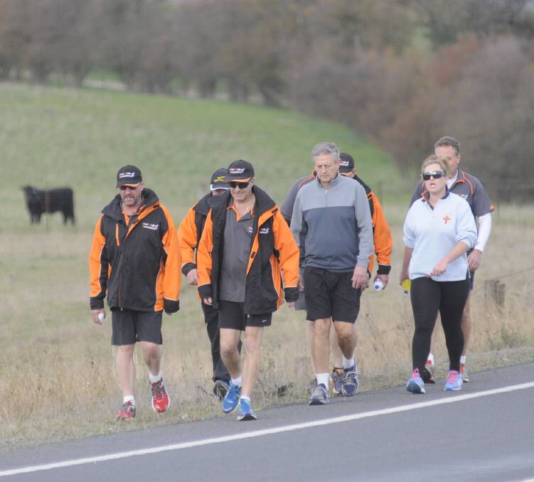 WALKING FOR CHARITY: Scott Macallister with Jonathan Green and walkers involved in The Great Walk fundraiser were pictured walking along the Oberon Road as they set off on their long journey on Monday. Photo: CHRIS SEABROOK 	052515cgtwalk