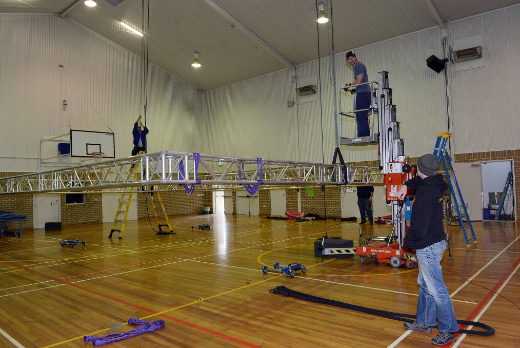 RIGGED: Trevor Gunter, Ben Bloomfield and Gavin Smith were in Kelso High School’s gym yesterday raising Cirkus Surreal’s brand new truss. Photo: PHILL MURRAY 082214pkelso