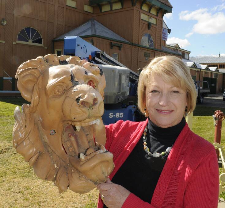 PRESERVING HISTORY: Bathurst Showground Trust secretary manager Christine Curry in front of the iconic Beau Brown Pavilion, which is being given a facelift. She is holding a tin lion’s head which is set to be restored and returned to the upper parapet on the building. Photo: CHRIS SEABROOK 081114cbeau3
