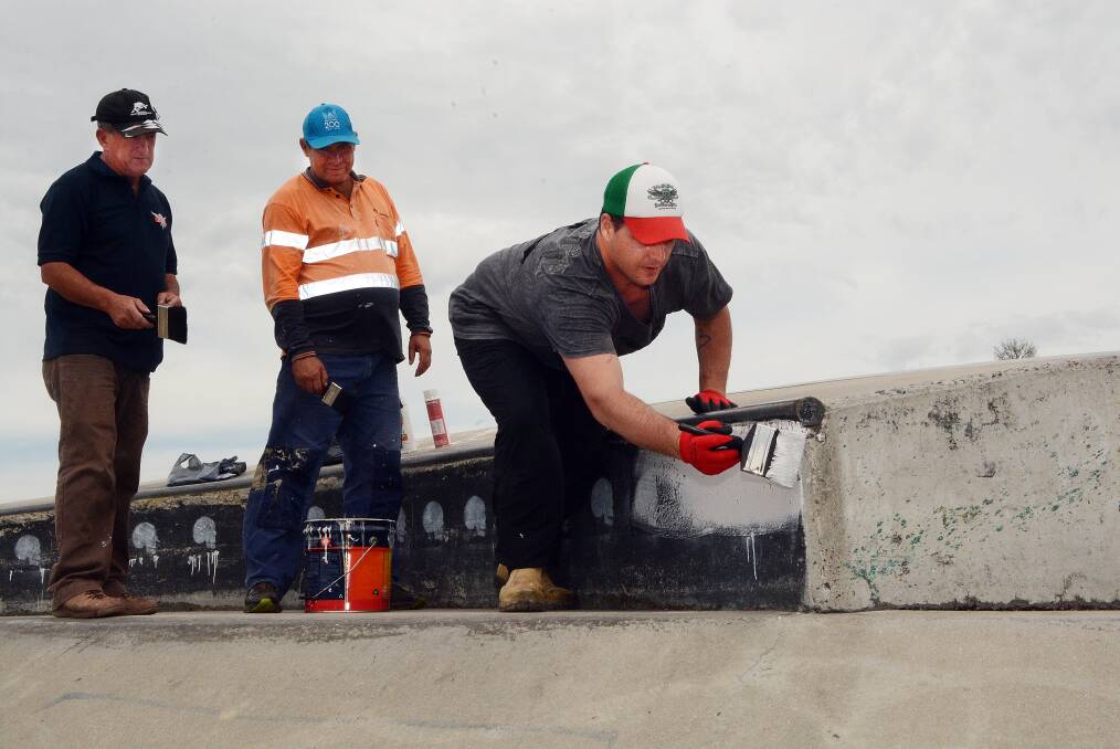 LEND A HAND: Volunteers Councillor Bobby Bourke, Bruce Morgan and Sonny Theobald get an early start on covering up some of the graffiti at the Bathurst Skate Park. They hope more volunteers will join them tomorrow. Photo: PHILL MURRAY 102414pgraffi