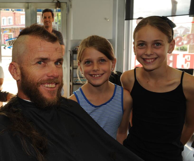 BALD AMBITION: Paul Twohill pictured with his daughters Heidi and Eve during his fundraising head shave at Bathurst Barbers last month. Photo: CLARE LEWIS 031415hair4