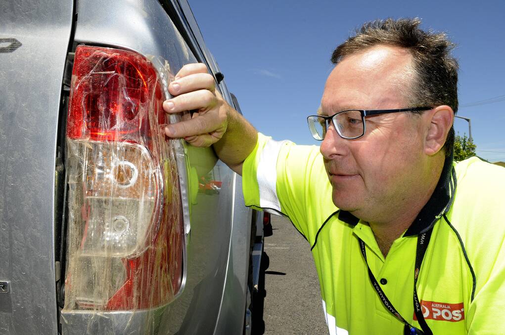 JUST RUDE: Brian Newby looks over the rear driver’s side indicator cluster that was damaged in a Bathurst car park last week. Whoever caused the damage drove off without leaving any details. Photo: CHRIS SEABROOK 111714cparker