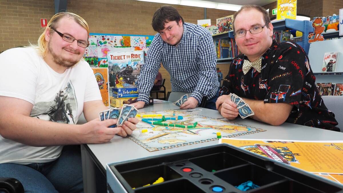 BOARD GAME FANS: Todd and Noel Hardacre with Adam Hock are looking foward to International TableTop Day. Photo: ZENIO LAPKA 033114ztabletop