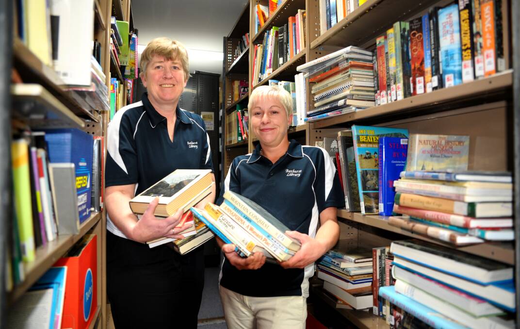 READ ALL ABOUT IT: Jane Cook and Tracy Collins prepare for the Giant Book Sale at Bathurst City Library. Photo: ZENIO LAPKA 091514books