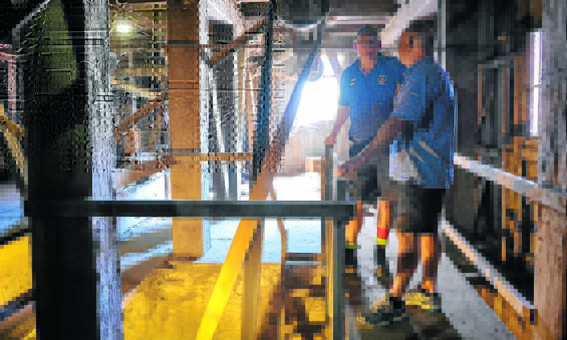STILL IN USE: Bedwells Feed Barn owner Chris Frisby with Michael Tremain, a descendant of William Tremain, take a tour through the old Tremain’s Mill silos which are still used by Bedwells. The site will soon be up for sale. Photo: ZENIO LAPKA                  020515ztremain-1-5