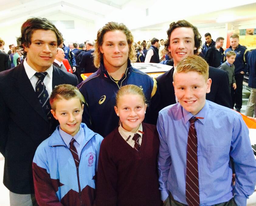 LOVING THEIR RUGBY: Holy Family 10s players Jayden Fisher (front, left) and Bailey Warren (front, right) as well as school captain Molly Brown recently caught up with Wallabies star Michael Hooper (back, middle), as did St Stanislaus’ pair Braedon Burns (left) and Brae Roebuck (right). 081214holyFamily