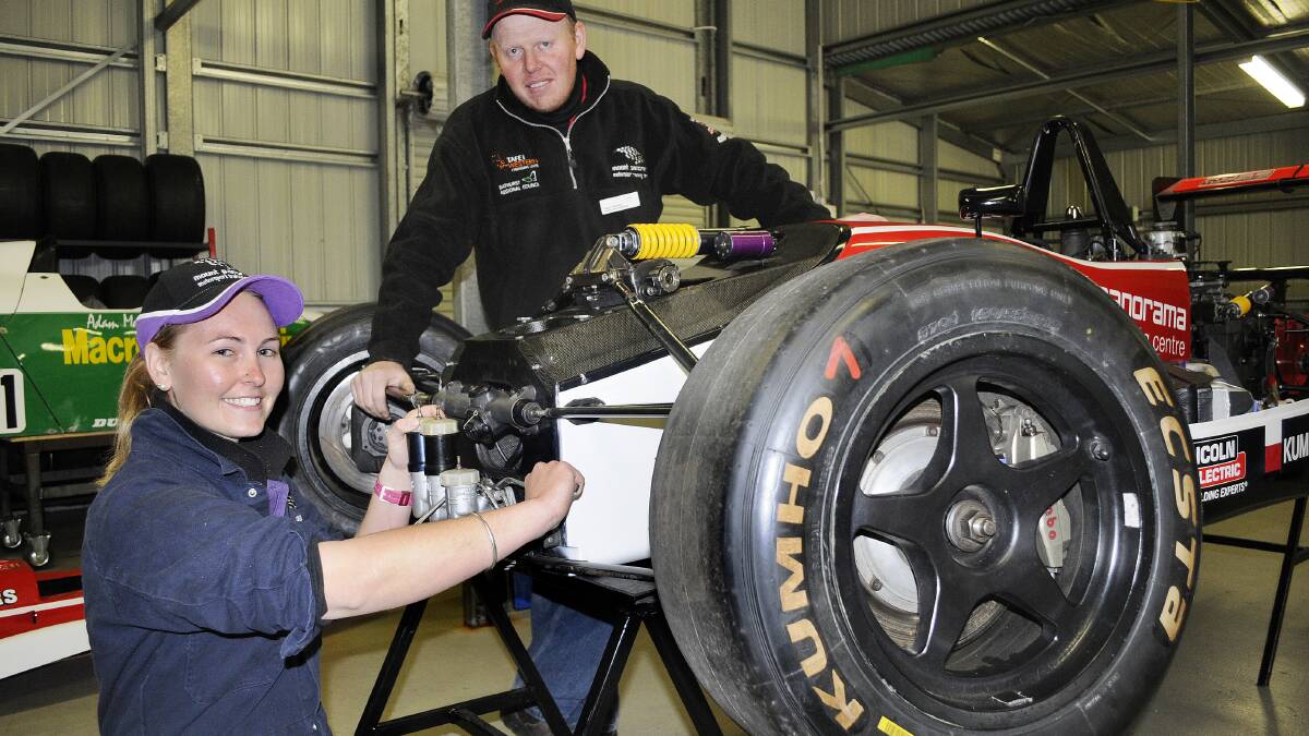 HARD AT WORK: Amy Rimmer at work on a Dallara F3 with her teacher, TAFE Western motorsport co-ordinator Nigel Buttriss, in their complex at Mount Panorama. Photo: CHRIS SEABROOK 050614ctafe