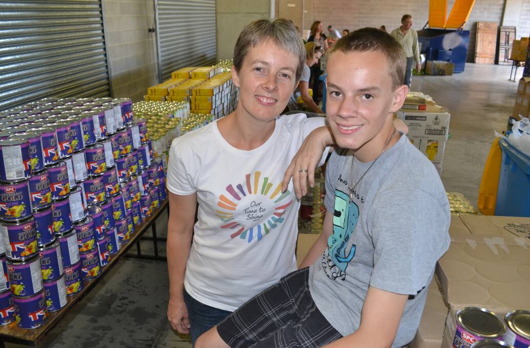 HERE TO HELP: Cassandra Jones brought her son Matthew along to the pit complex at Mount Panorama yesterday morning to help prepare for the Christmas Miracle Appeal hampers to be packed tomorrow morning. Photo: BRIAN WOOD 