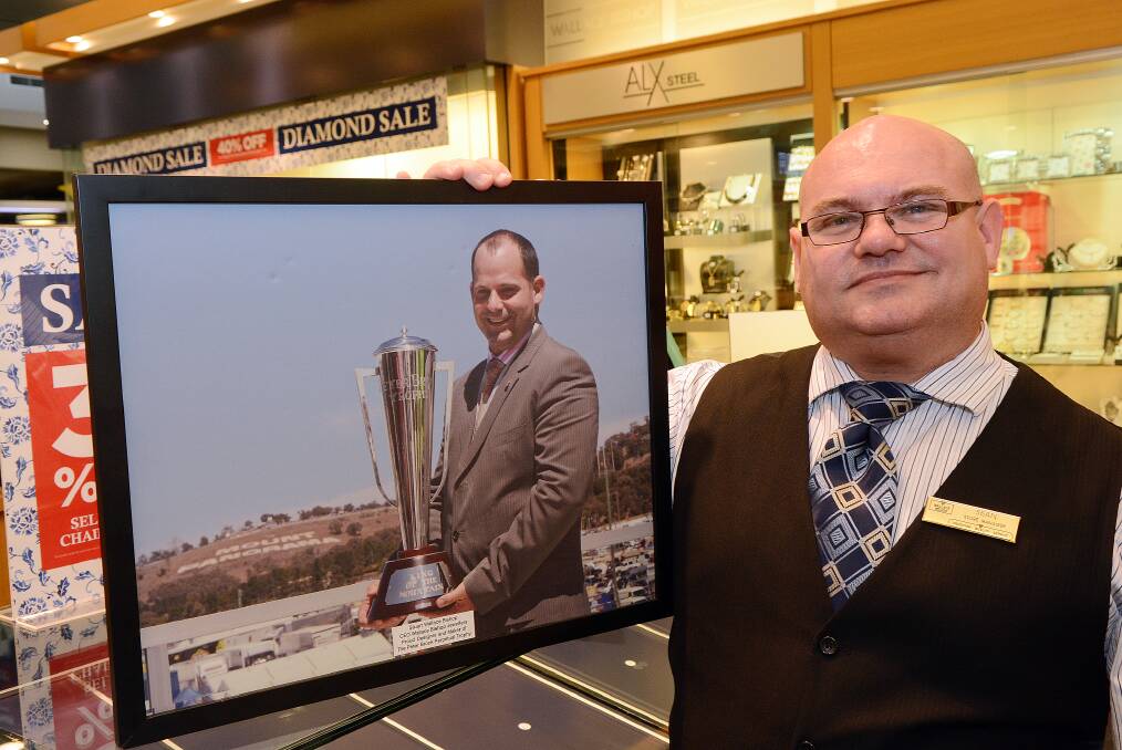 ICONIC TROPHY: Wallace Bishop manager Sean Finkel with a photograph of the Peter Brock trophy which will be in the store for a week from today in the lead up to the Bathurst 1000. 092514pbrock