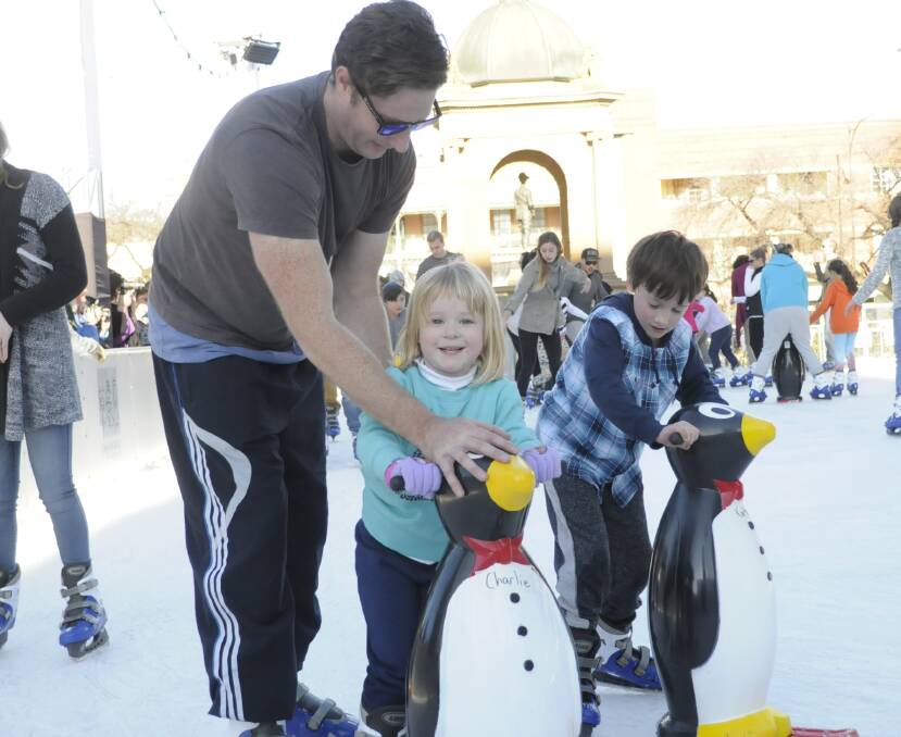 STEADY AS SHE GOES: Leigh Hands gently guides his daughter Alice, 4, around the ice rink with help from a penguin skating aid. Photo: CHRIS SEABROOK 070515cicer1