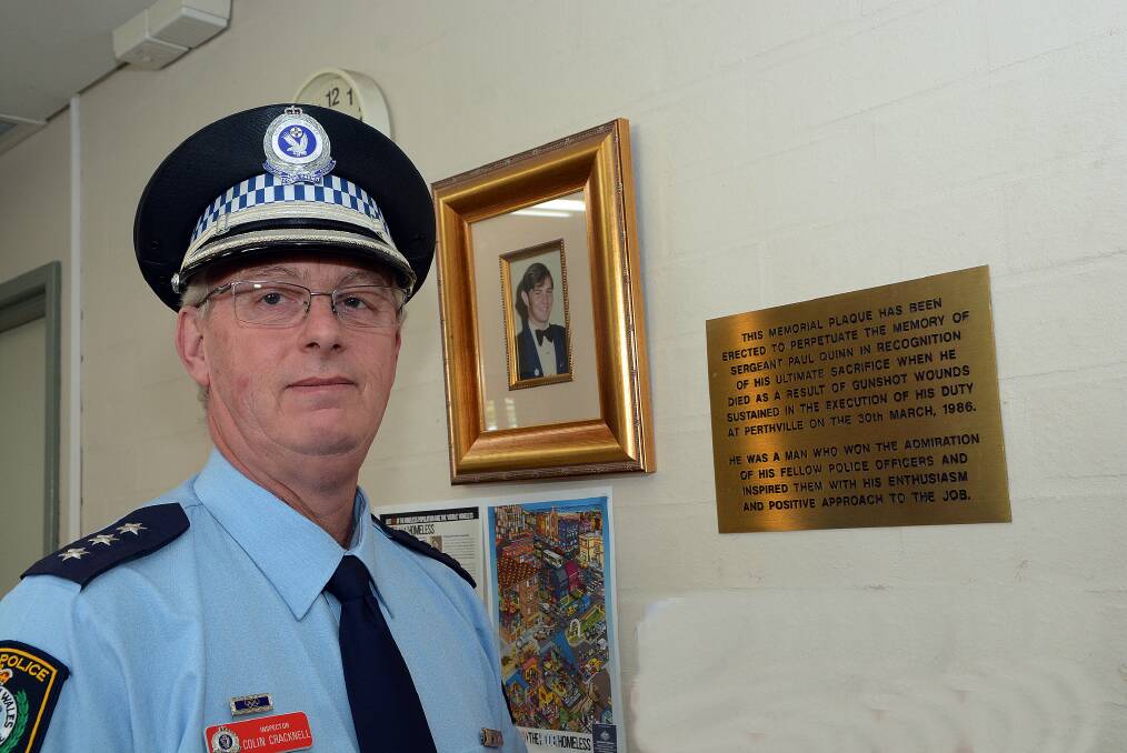 NEVER FORGOTTEN: Inspector Colin Cracknell standing alongside a plaque erected at Bathurst Police Station in memory of Sergeant Paul Quinn, fatally wounded in the line of duty at Perthville, in 1986. 092314pcol