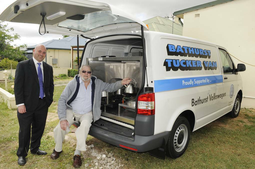 COMMUNITY SUPPORT: Bathurst Volkswagen general manger Shane Gilchrist hands over a brand new, refitted Tucker Van to co-ordinator David Buckby last November. Now there are fears the van could be off the road by the end of September. Photo: CHRIS SEABROOK 111113ctuckerv4