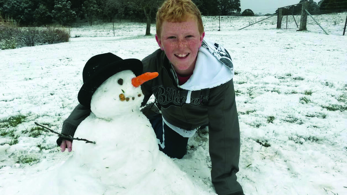 ME AND MY MATE: Cathedral School student Joseph Ryan, 11, had great fun building a snowman at Hillandale Garden and Nursery at Yetholme yesterday morning.