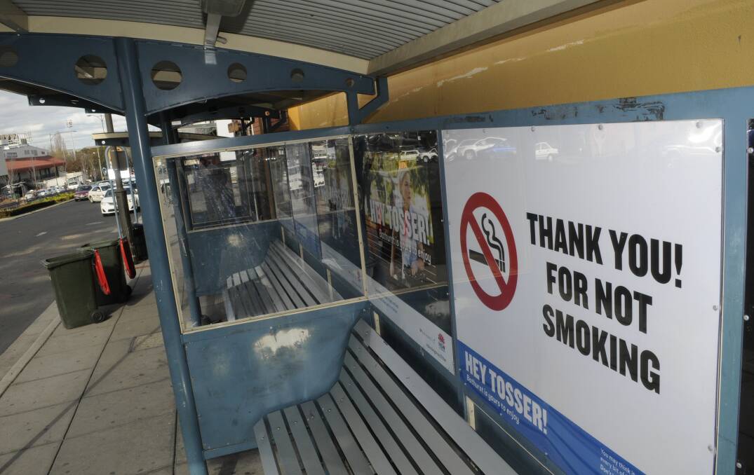 BUTT OUT: New no-smoking laws were introduced yesterday that will further restrict the places where Bathurstians can light up. Photo: CHRIS SEABROOK 070615cbusstop1