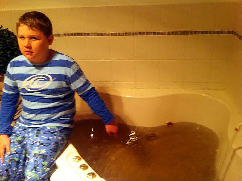 YUCK: Jack Bowker inspecting the water colour in the bath tub at his Llanarth home on Tuesday night. 061114dirty