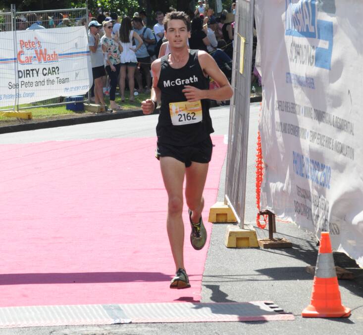 FEELING THE HEAT: Harry Summers crosses the finish line to take out the 5km event. Photo: MARK LOGAN 0301mlrunning21